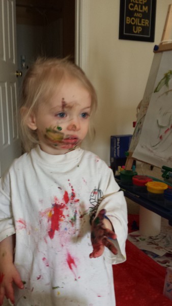 Looking glum after getting more paint on her face than on the paper